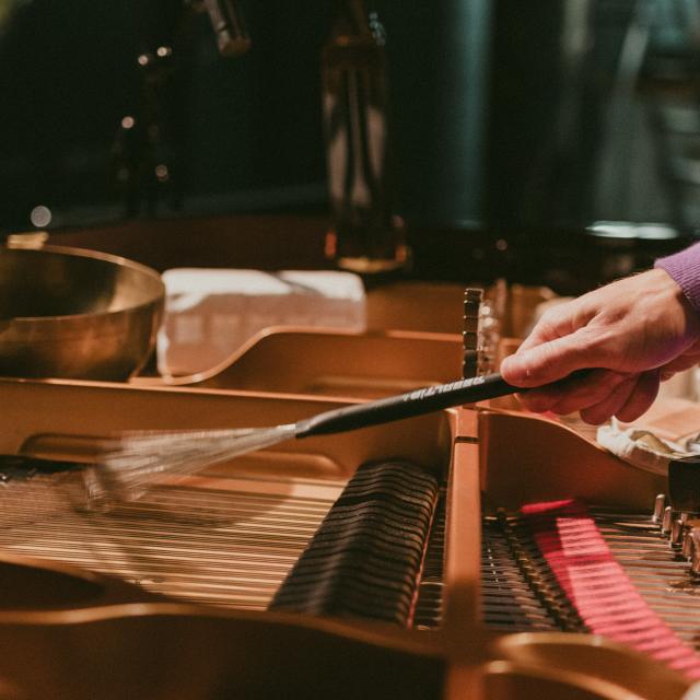 Playing the piano with drum brushes. 