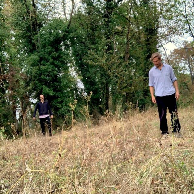 Gamut and Insub on the field, surrounded by trees, performing